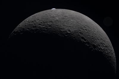 Earthrise peeking over the Moon with lens flare